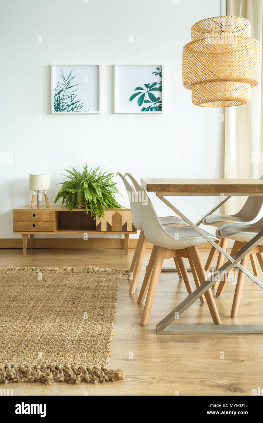 Lampe Uber Dem Esstisch Mit Weissen Stuhlen Im Speisesaal Mit Floralen Poster Uber Schrank Mit Farn Und Lampe Stockfotografie Alamy