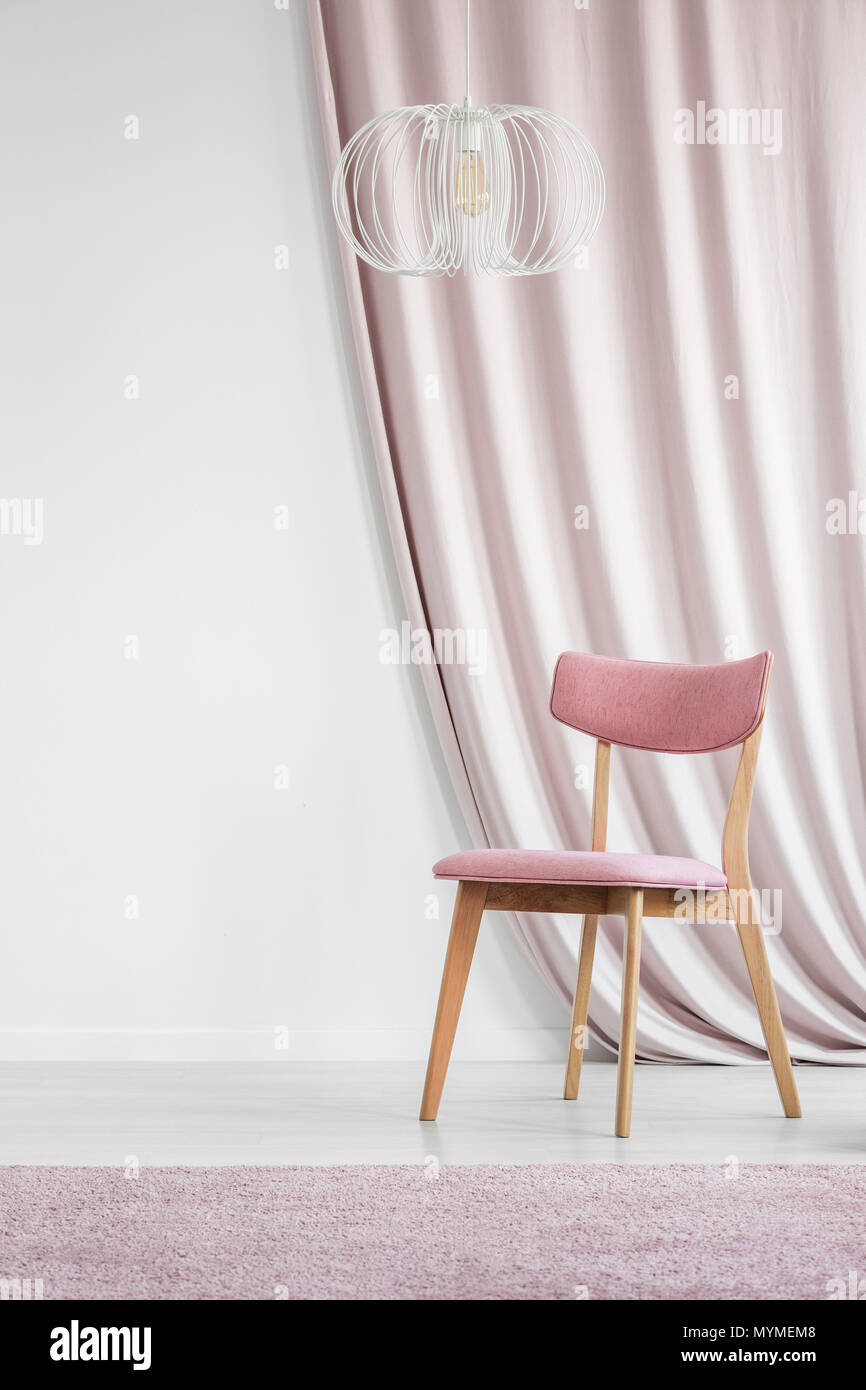 Pastellrosa Stuhl, Teppich und Stoff in Weiß Wohnzimmer Interieur mit leeren Wand Stockfoto