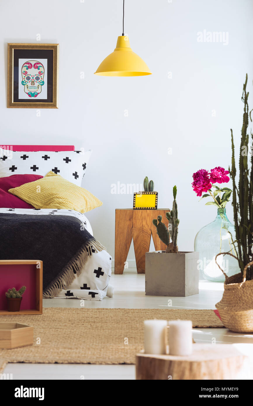 Folk moderne Schlafzimmer mit Bett, mexikanische Schädel Poster und Cactus Stockfoto