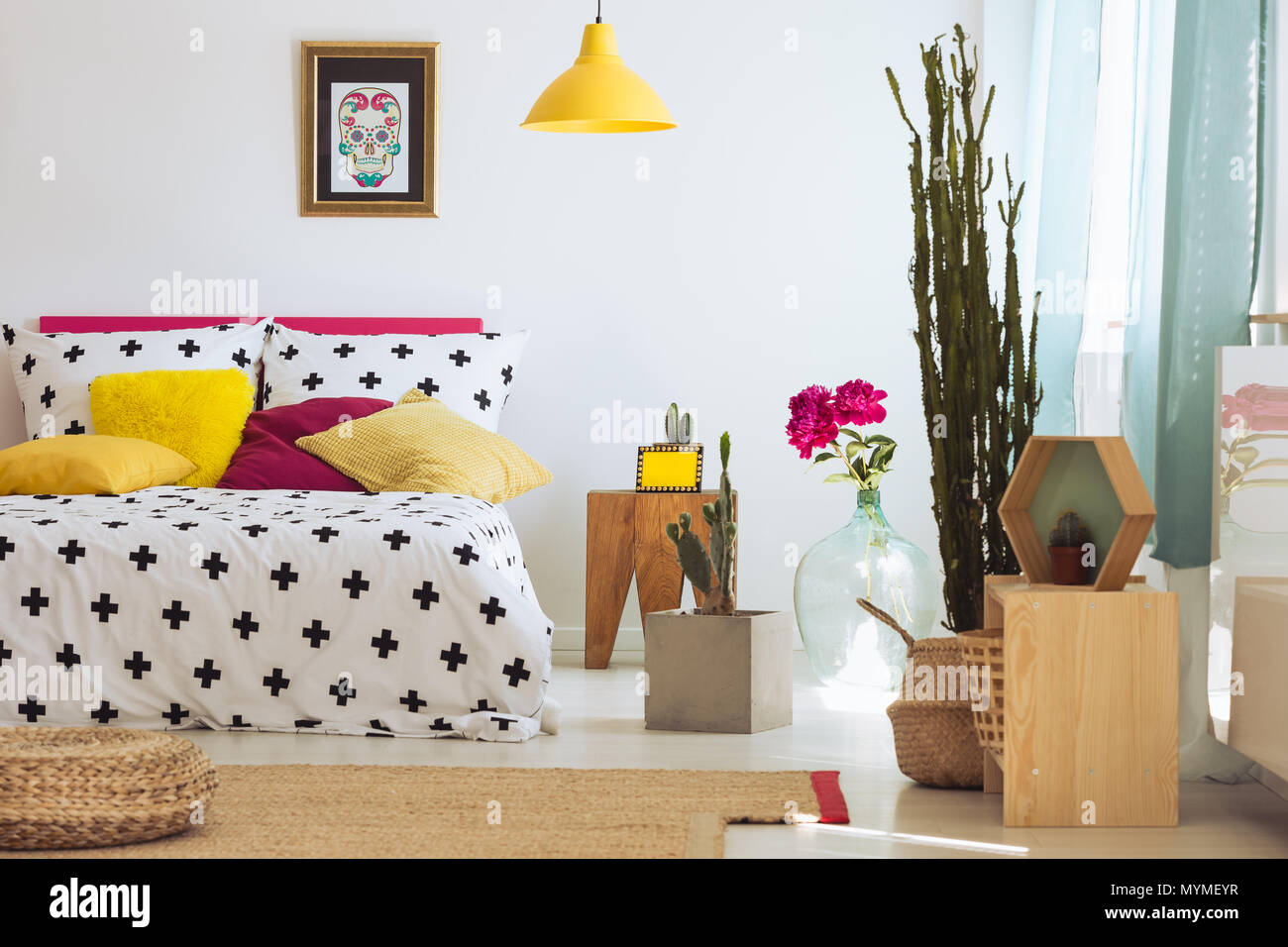 Helle einzigartiges Schlafzimmer mit Pflanzen, Teppich, Poster und bunte Kissen Stockfoto