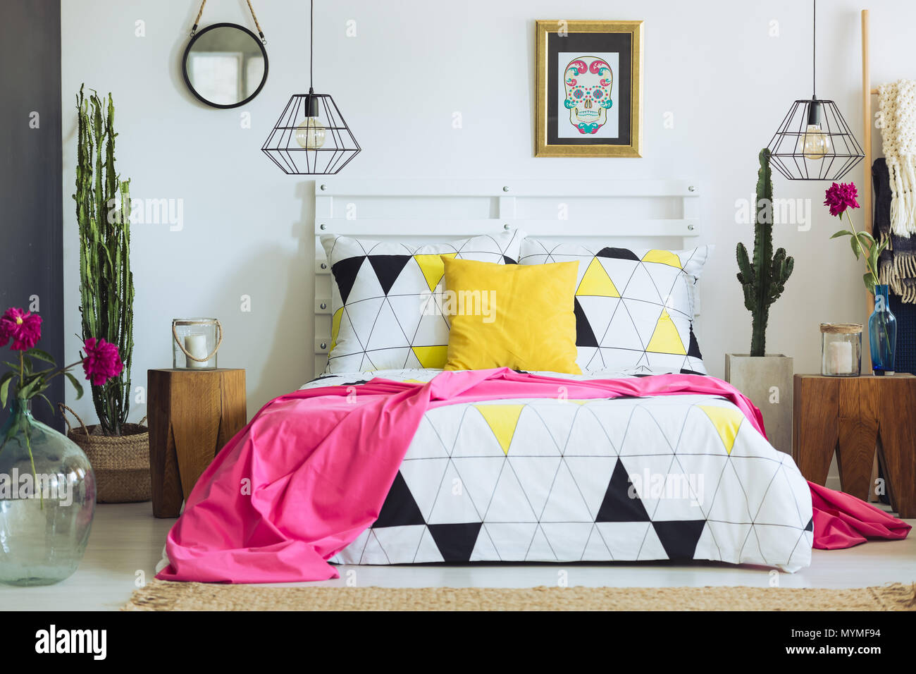 Einzigartige weiße Schlafzimmer mit bunten Kissen, geometrische Bettwäsche und Cactus Stockfoto