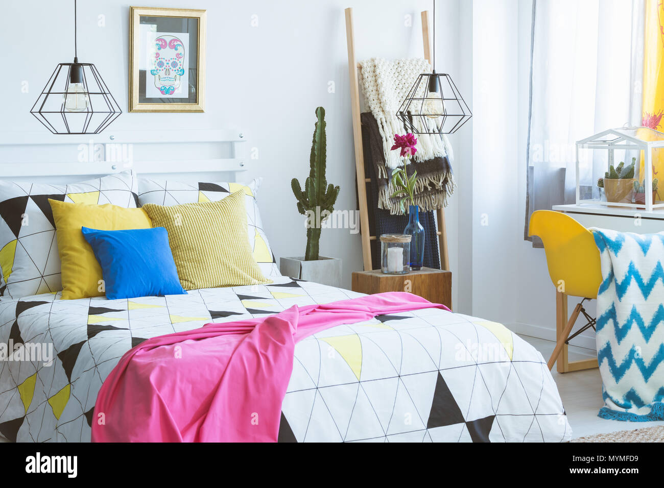 Gemütliches Schlafzimmer mit farbigen Akzenten, moderne Möbel und Folk details Stockfoto
