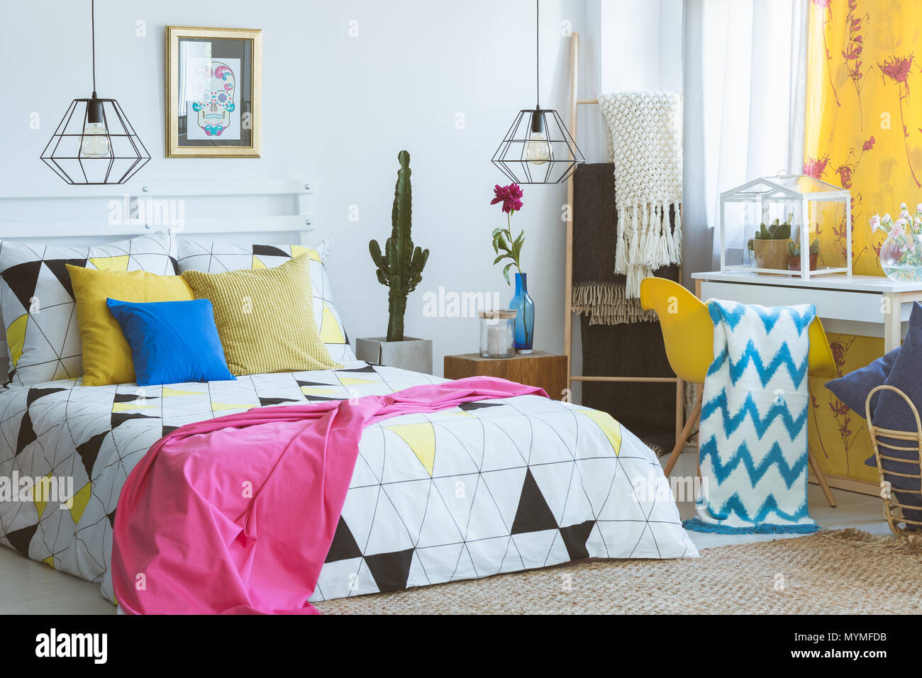 Farbenfrohe Schlafzimmer mit gelben Sessel und Glas Terrarium mit Cactus Stockfoto