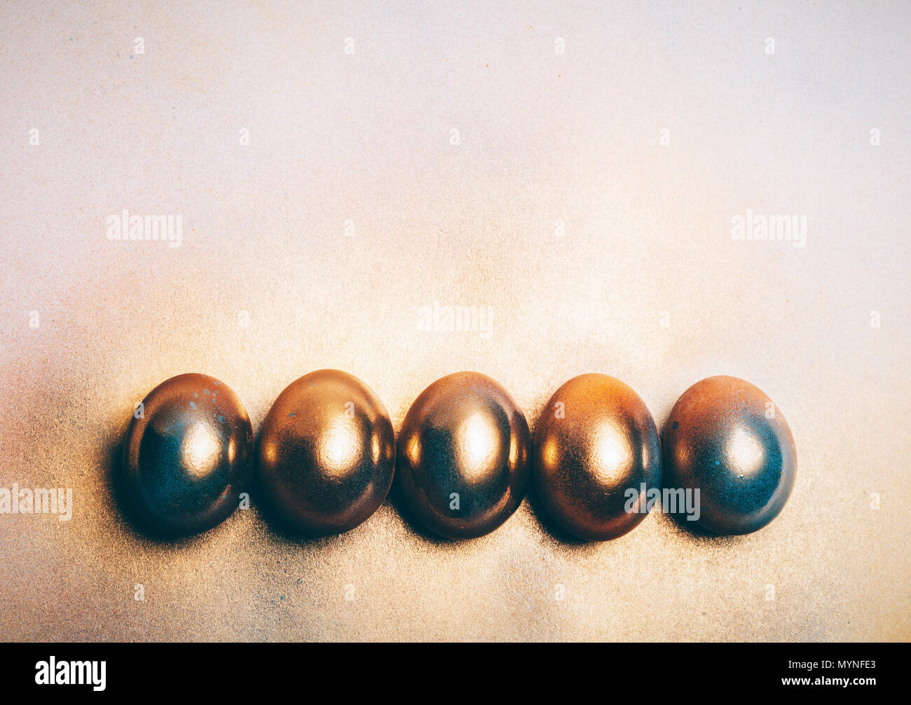 Fünf goldene Eier auf den Boden. Minimale Dekoration. Easter Egg. Stockfoto