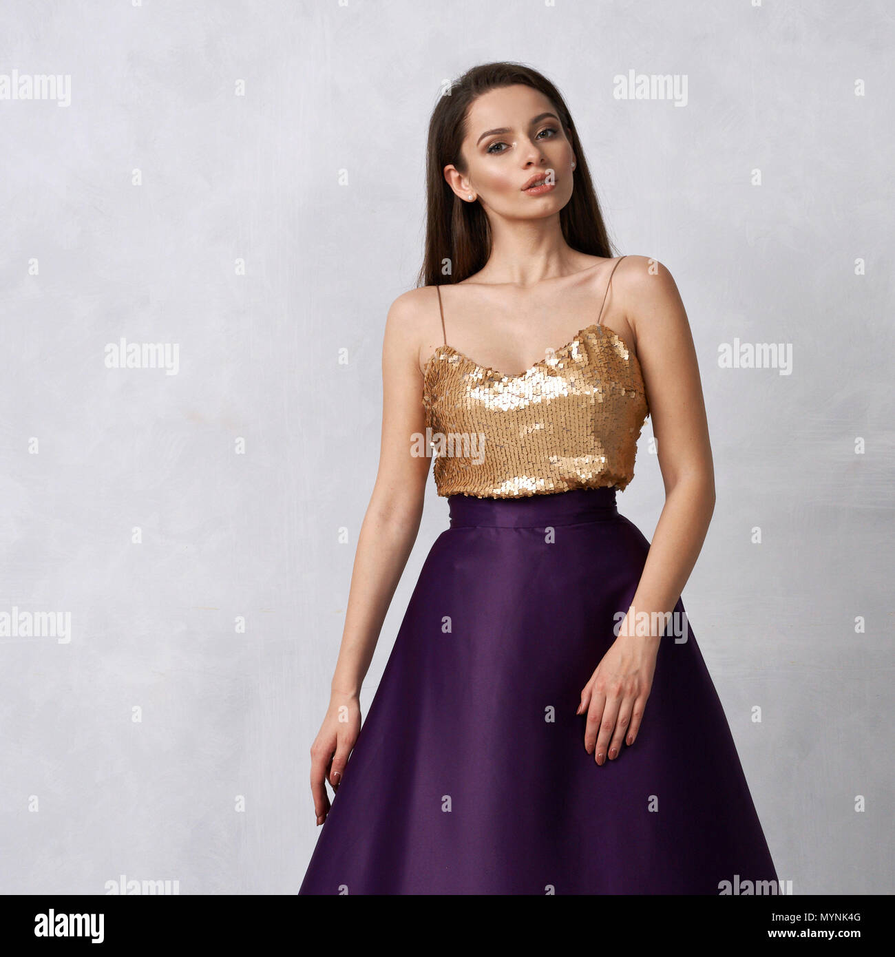 Junge Frau in formalen Kleid mit goldenen Pailletten Top und Lila sa  Stockfotografie - Alamy