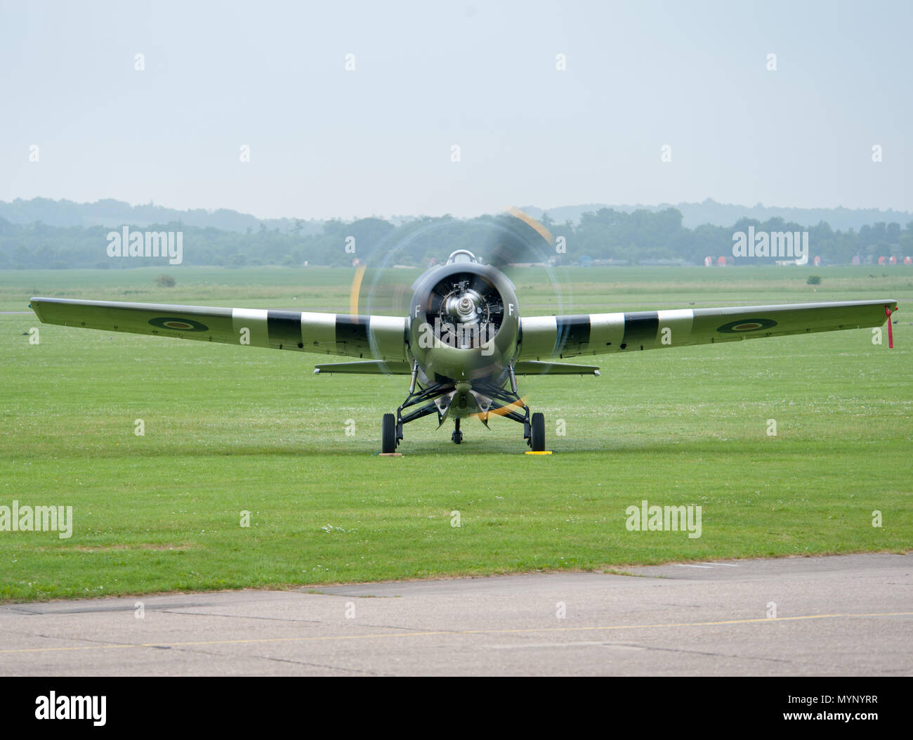 Oldtimer-Militärflugzeug mit drehendem Propeller auf dem Flugplatz der IWM Duxford, Cambridgeshire, Großbritannien, während eines historischen Flugturniers oder einer Ausstellung Stockfoto