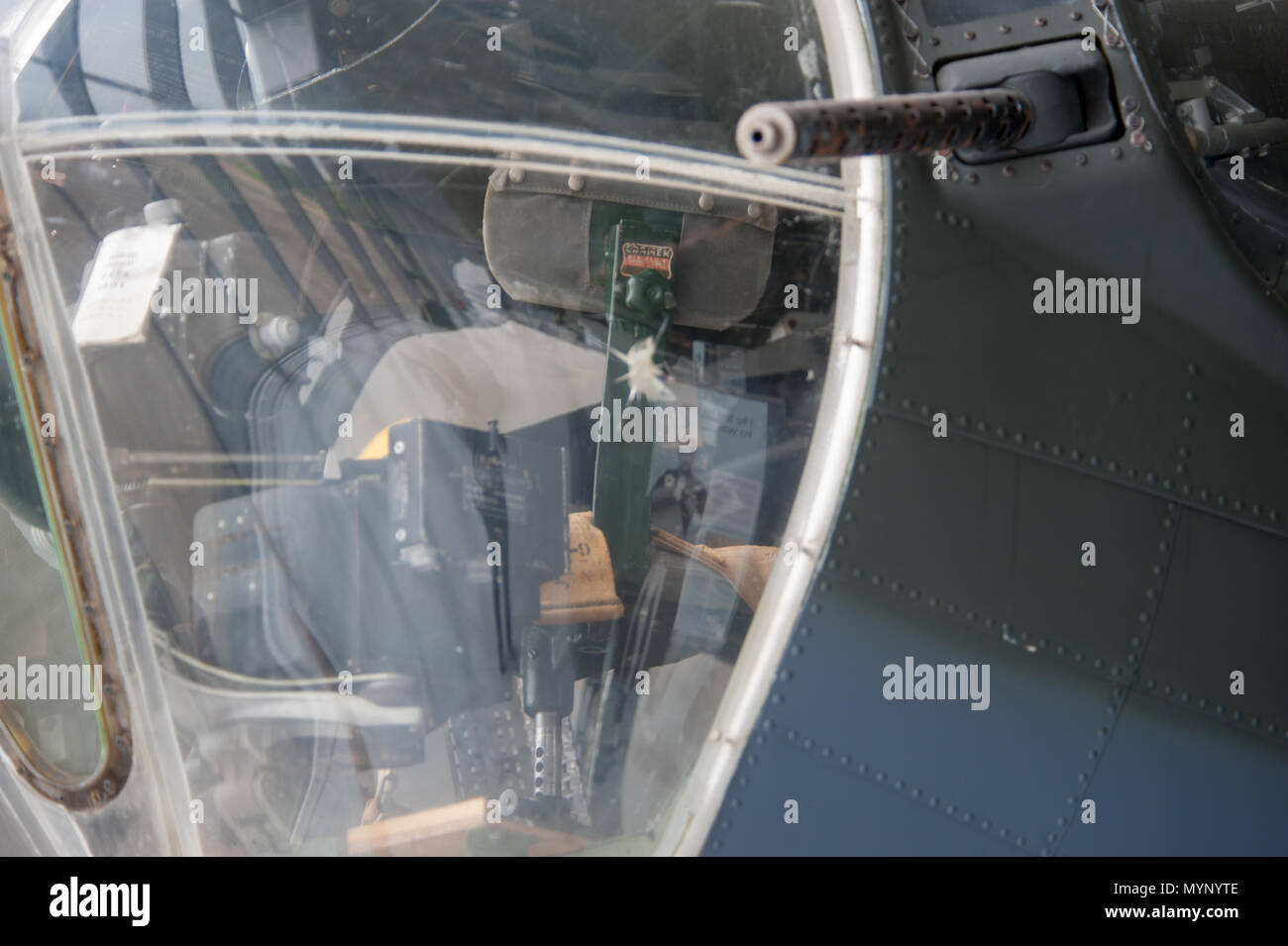 Nahaufnahme des Turms und des Cockpits eines Oldtimer-Militärflugzeugs mit sichtbarem Geschützrohr und Bedienelementen im Inneren, ausgestellt auf der IWM Duxford, Großbritannien. Stockfoto