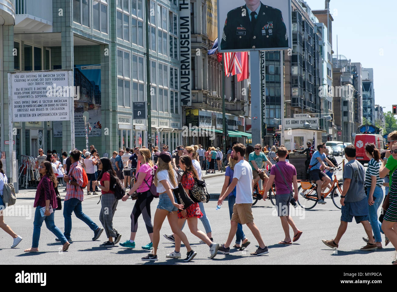 Berlin, Deutschland - Juni 2018: Leute auf der Straße am Checkpoint Charlie in Berlin Mitte. Der ehemalige Grenzübergang ist ein berühmter Sehenswürdigkeiten ein Stockfoto