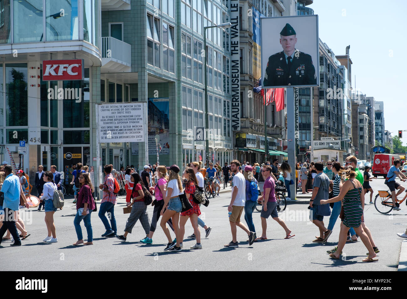 Berlin, Deutschland - Juni 2018: Menschen auf der Straße am Checkpoint Charlie an einem sonnigen Sommertag in Berlin Mitte. Der ehemalige Grenzübergang zählt Stockfoto