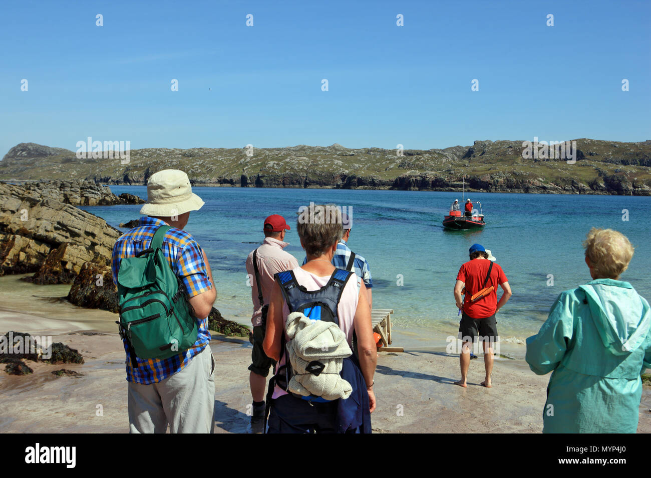 Besucher Handa Island, National Nature Reserve, Warten auf Tarbet auf die kleine Fähre nähert, landet auf dem Strand zurückzukehren. Stockfoto