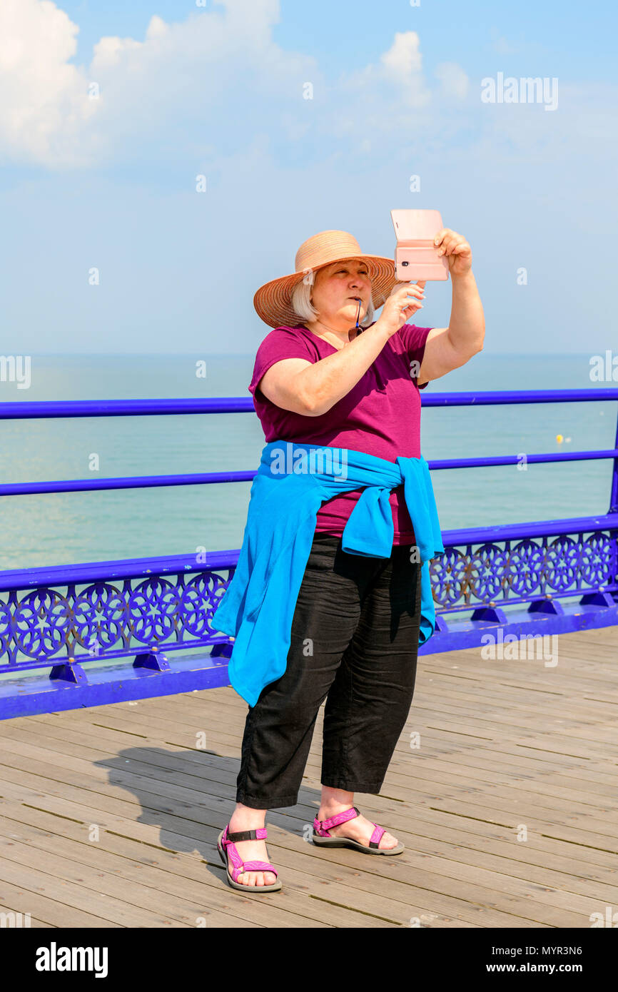 Frau mittleren Alters eine selfie auf Eastbourne Pier Stockfoto