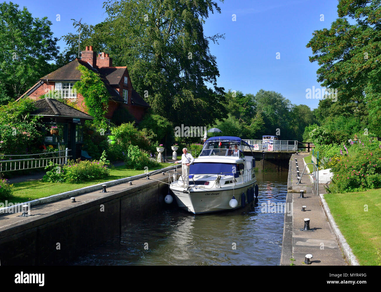 Privates Ausflugsboot in der Sonning Lock auf der Themse im Dorf Sonning, Reading, Berkshire, an einem wunderschönen sonnigen Sommernachmittag Stockfoto