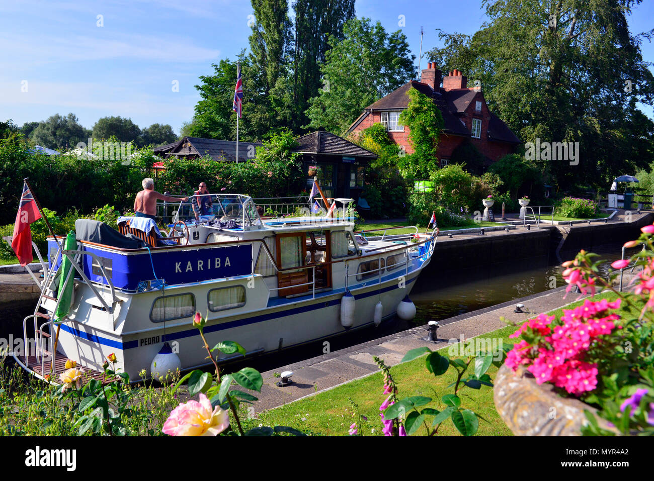 Privates Ausflugsboot in der Sonning Lock auf der Themse im Dorf Sonning, Reading, Berkshire, an einem wunderschönen sonnigen Sommernachmittag Stockfoto