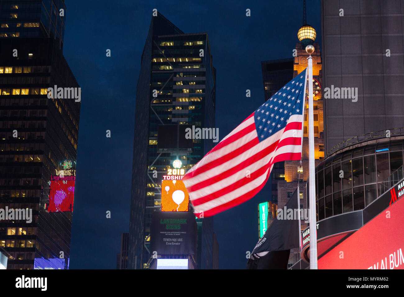 Die amerikanische Flagge im Times Square bei Nacht fliegen, Times Square, New York City, Vereinigte Staaten von Amerika; Konzept - Kapitalismus Stockfoto