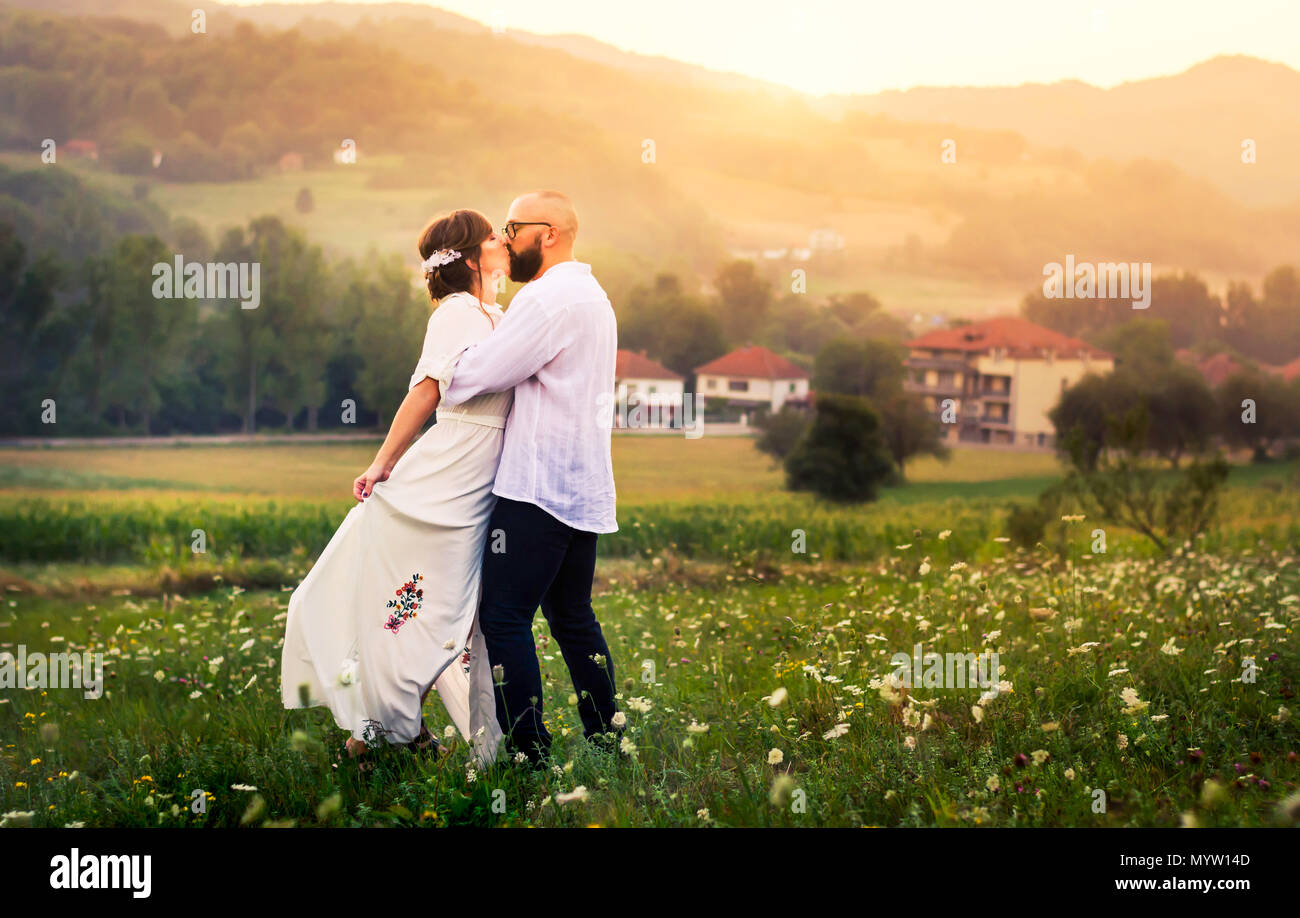 Paar Küssen in das Feld mit den romantischen Sonnenuntergang Stockfoto