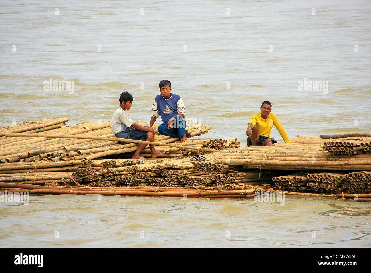 Einheimische Männer schwimmend auf einem Bambus raft Ayeyarwady Fluss in der Nähe von Mandalay, Myanmar. Ayeyarwady Fluss ist der größte Fluss in Myanmar. Stockfoto