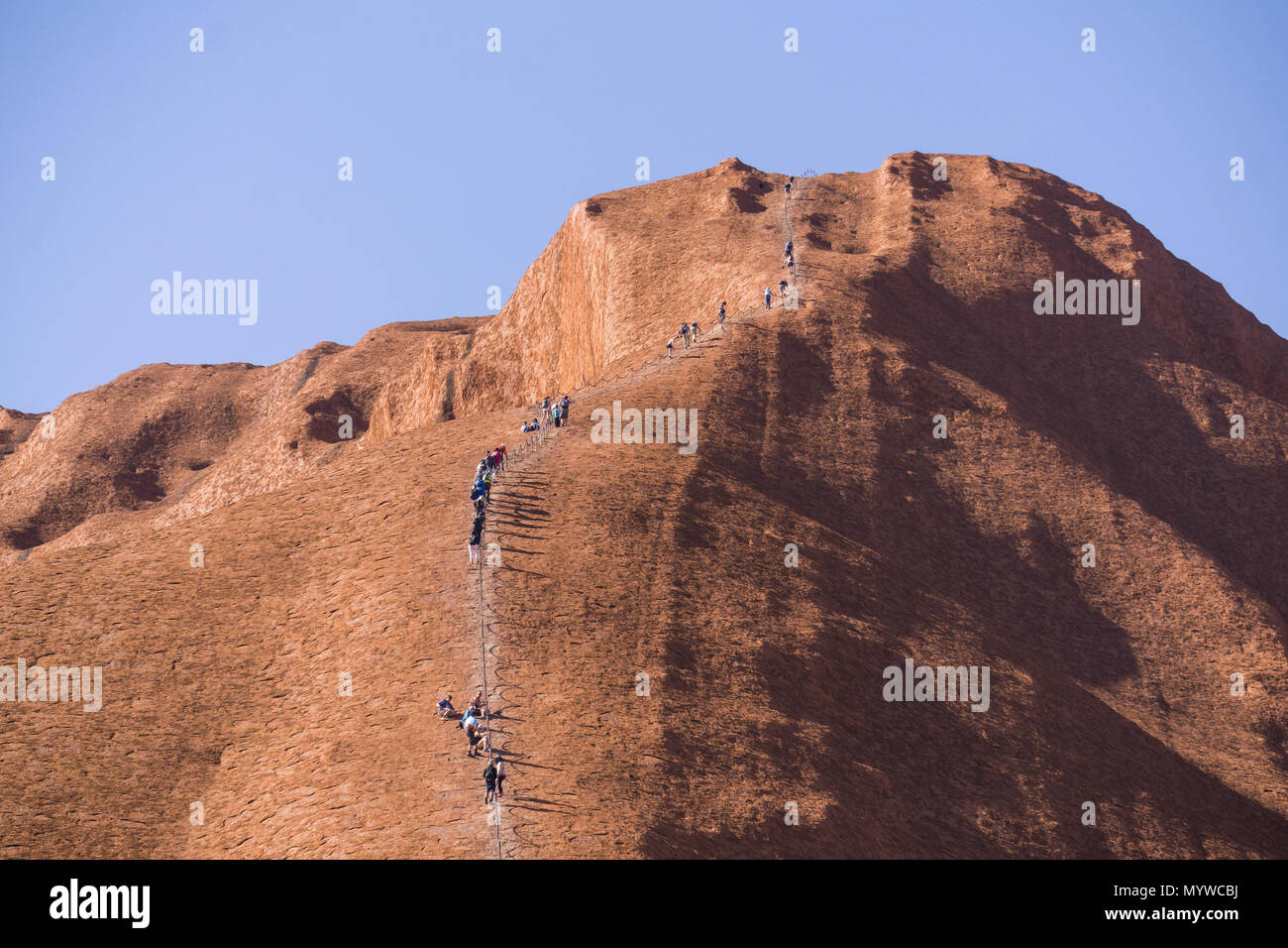 Zu Fuß bis Uluru oder Ayers Rock im Outback von Australien. Die Praxis ist unpopulär mit traditionellen Eigentümer des Landes und wird im Jahr 2019 verboten. Stockfoto