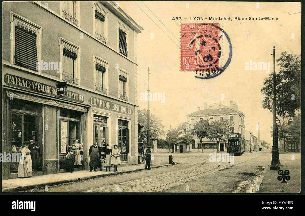 . Es gibt ein Gebäude und einen Platz. Es ist ein 2-stöckiges Gebäude. Wir sehen vier Fenster. Im Erdgeschoss befinden sich Geschäfte. Auf den Zeichen ist zu lesen: "Tabak Witwe Calandras Counter' und 'Counter Berthollet'. Auf dem Bürgersteig vor dem photogaph, Händler außerhalb für das Bild. Die Straße geht an einen runden Platz. Zusammen sind sie große Häuser und Somme Wände. Also, auf der anderen Seite des Platzes ist ein 2-stöckiges Haus mit 5 Fenstern und einem Shop im Fuss. In der Mitte des Platzes befindet sich eine elektrische Straßenbahn, die ein Pol. Auf dem Dach ist zu lesen: "louit Choclat". Stockfoto