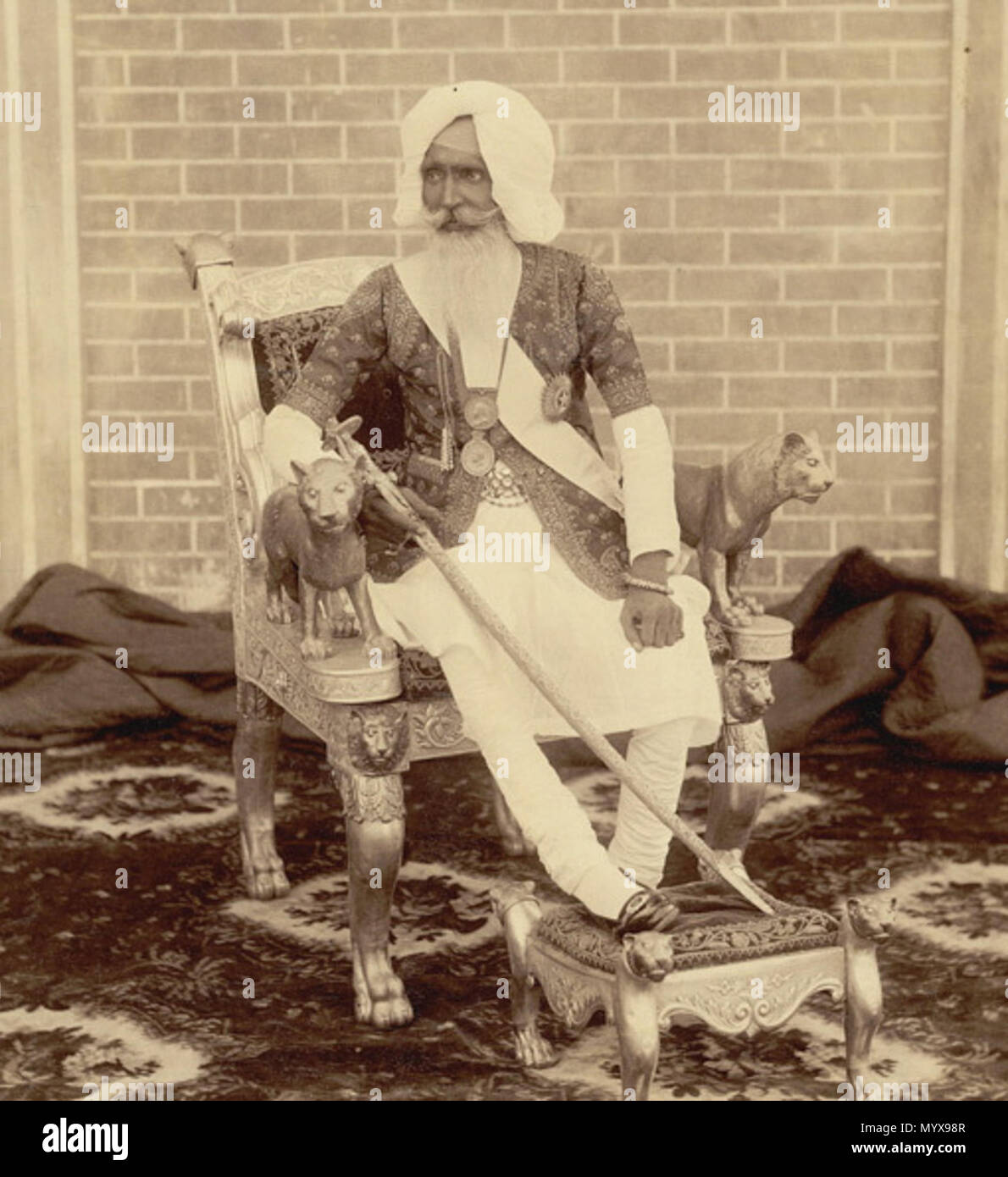 . Englisch: Sir Hira Singh, der Raja von Nabha, von einem unbekannten Fotografen in den 1890er Jahren genommen. Diese in voller Länge Porträt zeigt die Raja sitzt auf einem vergoldeten Thron mit seinem rechten Bein auf einen Hocker. Er ist in den königlichen Insignien inklusive Medaillen und halten ein Juwel - verkrustete Schwert gekleidet. Die Arme der Thron von geschnitzten Löwen gebildet. Der Raja (1843-1911) regierte die fürstlichen Zustand von nabha im Punjab von 1871 bis zu seinem Tod. Ein Sikh, er war ein Mitglied der Phulkian Dynastie gingen vom Sidhu Jats. Familien der Dynastie Patiala, Feudalstaat, Nabha, Bahadur und andere Punjab states. Nabha Stockfoto