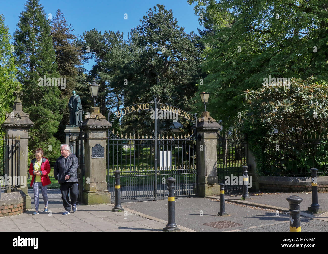 Leute an den Toren zu den Botanischen Gärten in Belfast mit einer Statue von Kelvin im Hintergrund. Stockfoto