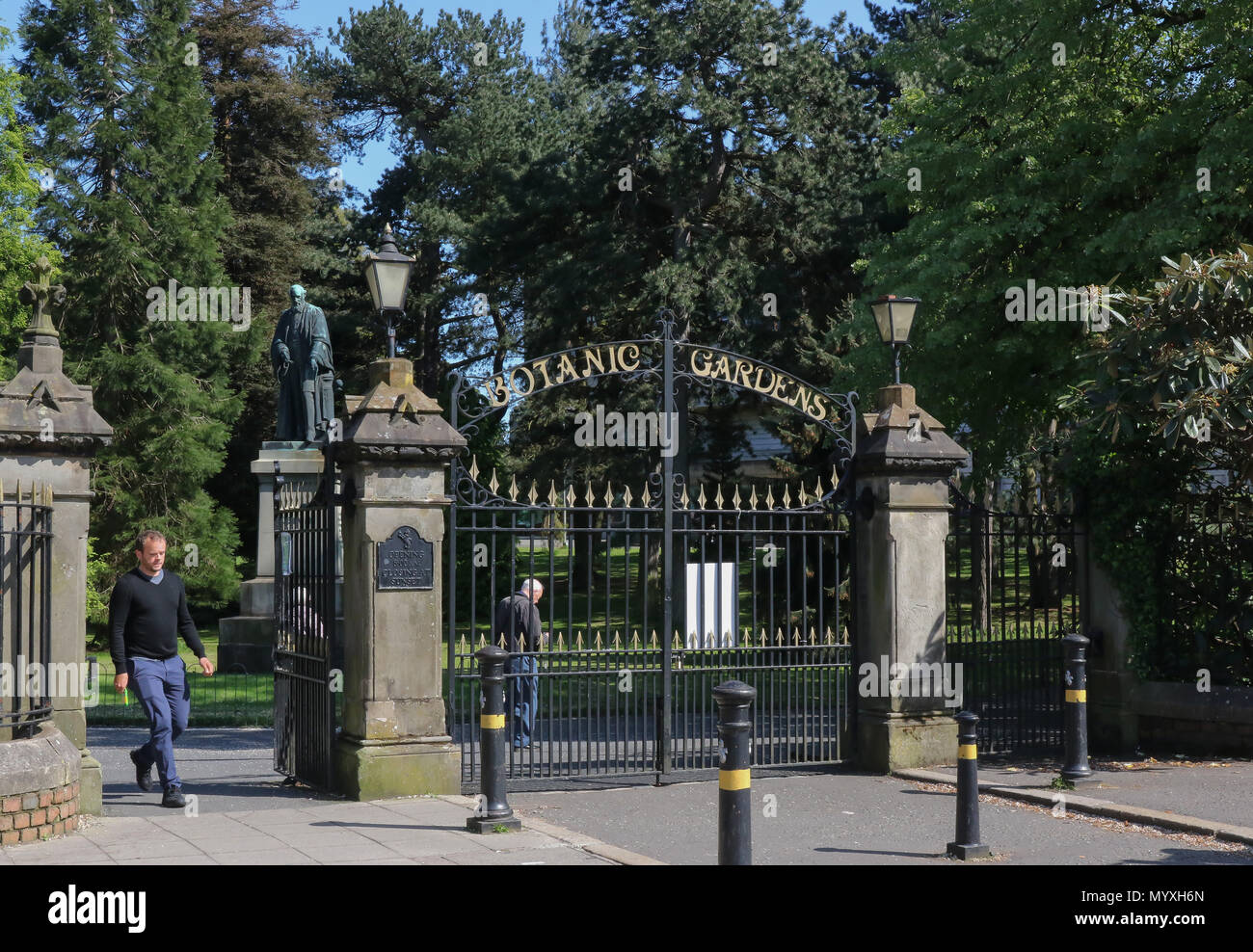 Leute an den Toren zu den Botanischen Gärten in Belfast mit einer Statue von Lord Kelvin im Hintergrund. Stockfoto