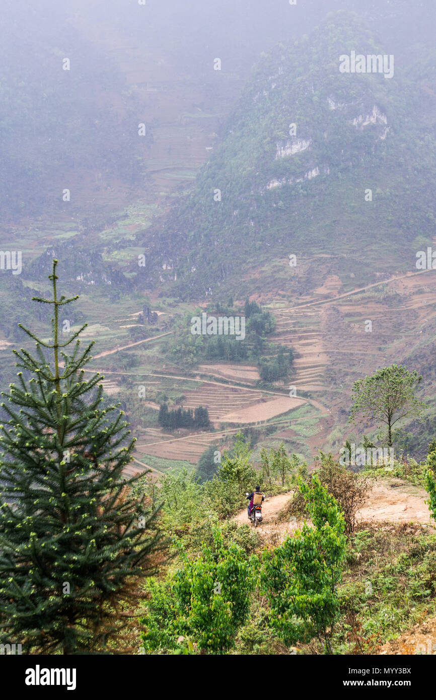 Ein Mann auf einem Moped seine Weise hinunter einen bergweg der Provinz Ha Giang, Vietnam Stockfoto