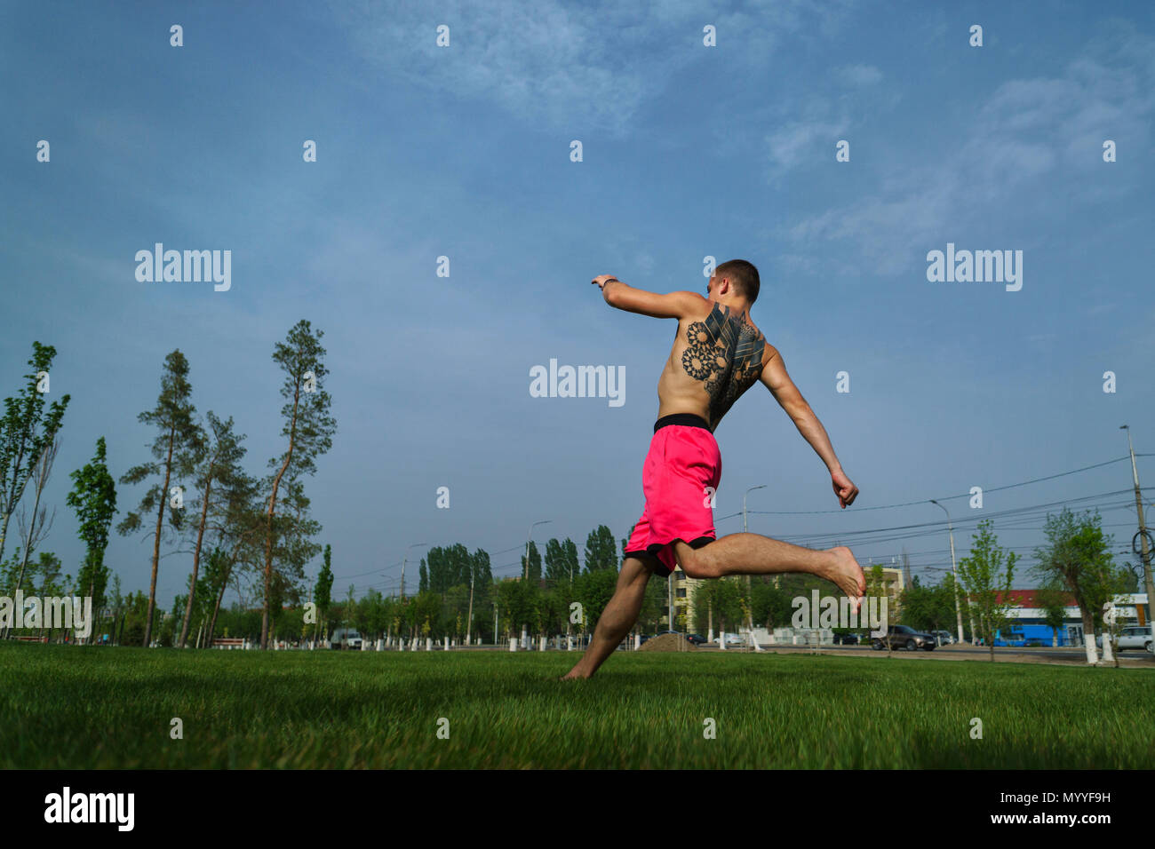 Austrickst, auf Rasen im Park. Der Mensch ist dabei laufen für springen. Kampfkunst und Parkour. Street Workout. Stockfoto