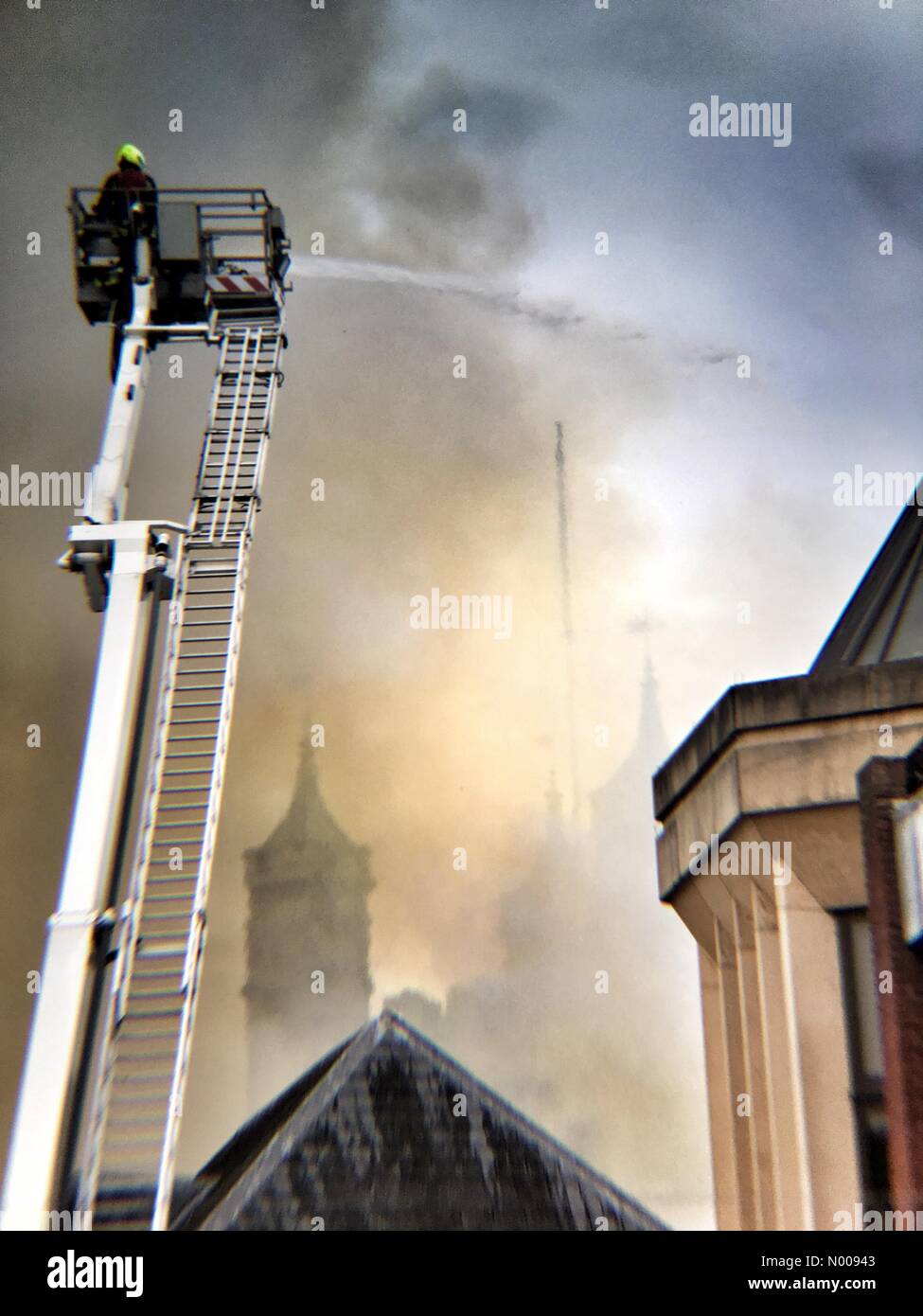 Spitze der Kathedrale von Exeter durch Rauch wie blaze geht weiter. Feuerwehr am Unfallort. Stockfoto
