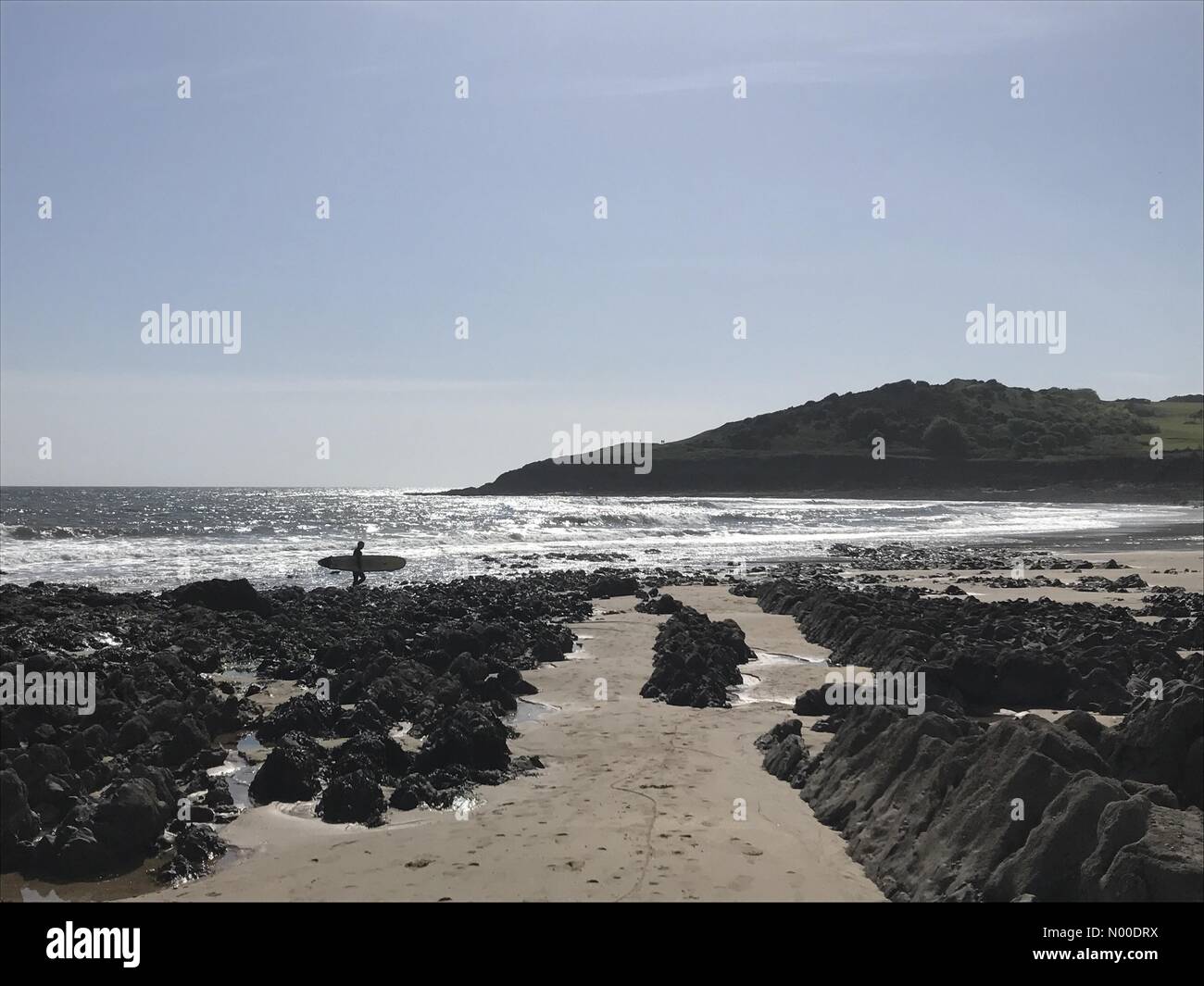 Rotherslade Rd, Newton, Swansea, Großbritannien. 14. Mai 2017. Eine einsame Surfer geht heute Nachmittag bei strahlendem Sonnenschein über Langland Bucht in der Nähe von Swansea. Bildnachweis: Phil Rees/StockimoNews/Alamy Live-Nachrichten Stockfoto