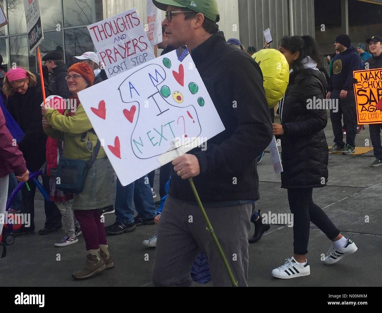 Seattle, Washington, USA. 24 Mär, 2018. Menschen zu Fuß holding Protest Poster auf Seattle Straße während der anti Gewehr März am 24. März 2018 Credit: Katya Palladina/StockimoNews/Alamy leben Nachrichten Stockfoto