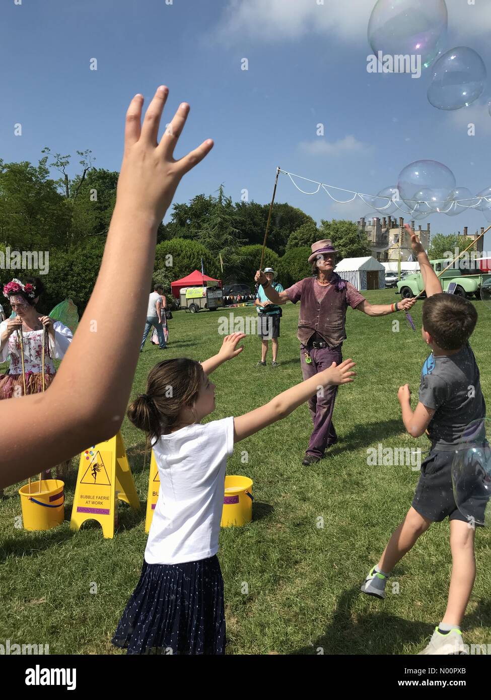 UK Wetter: Sherbourne, Dorset, 28. Mai 2018. Kinder fangen blasen Der bubbleman an einem heißen und sonnigen Tag an der jährlichen Sherborne Castle Country Fair auf Feiertag Montag. Stockfoto