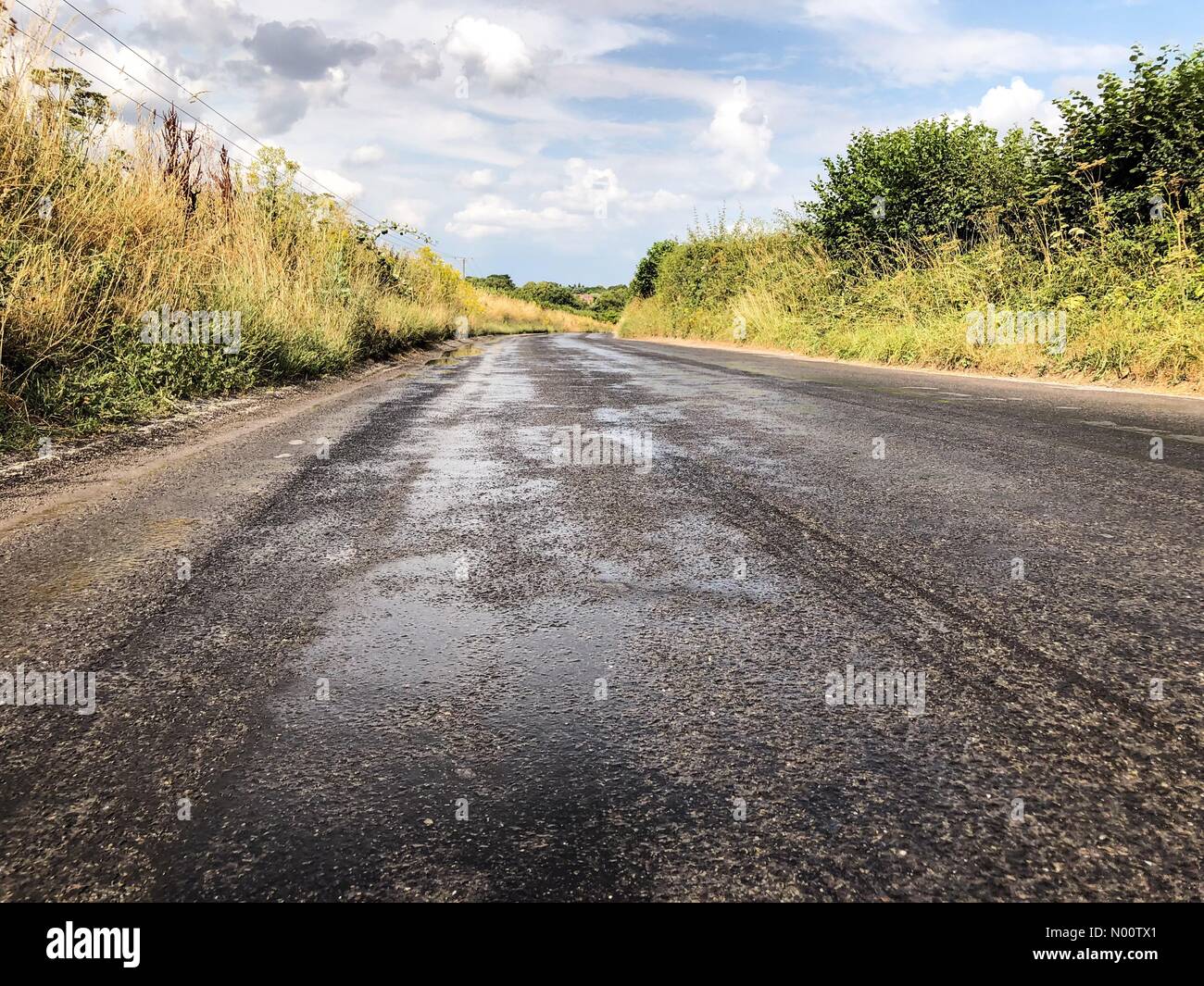 Godalming, Großbritannien. 24. Juli, 2018. UK Wetter: Geschmolzene Straßen in Godalming. Tuesley Lane Godalming. 24. Juli 2018. Hitzewelle im Südosten heute. Wasser auf den Straßen weiter schmelzen in Godalming, Surrey zu verhindern. Credit: jamesjagger/StockimoNews/Alamy leben Nachrichten Stockfoto