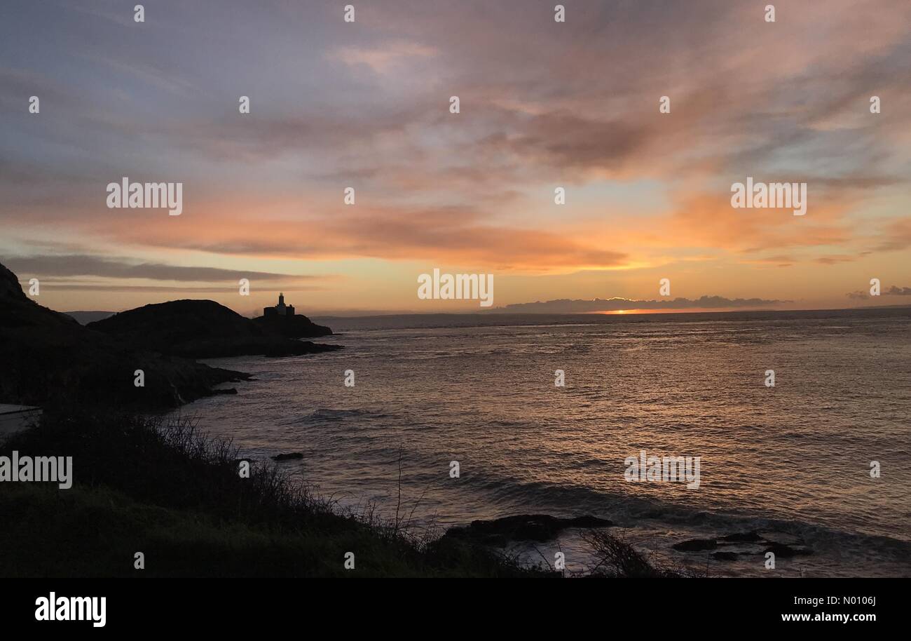 Armband Bay, Wales. 22. Jan 2019. UK Wetter: Sonnenaufgang am Armband Bay in der Nähe von Swansea heute morgen mit dem Mumbles Leuchtturm im Vordergrund. Credit: Phil Rees/StockimoNews/Alamy leben Nachrichten Stockfoto