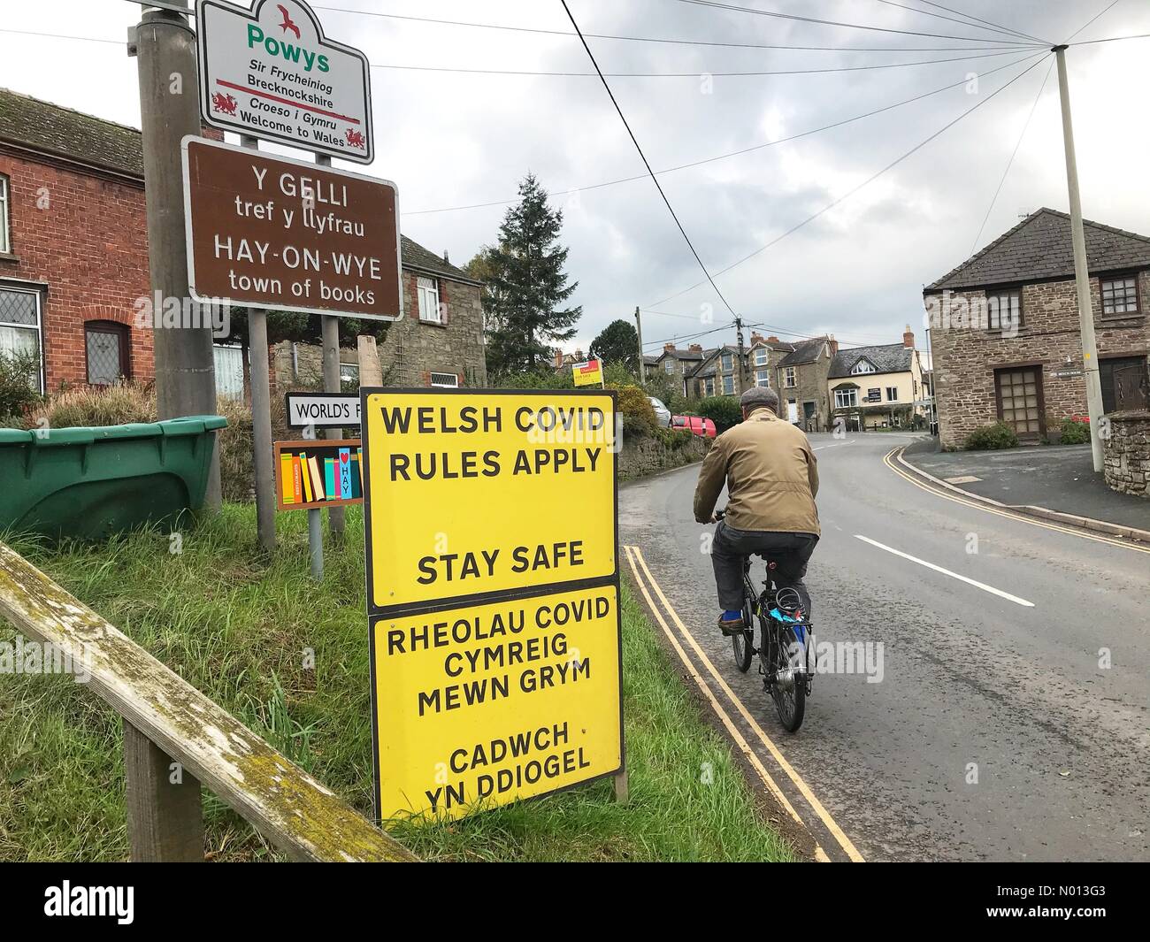 UK Coronavirus - Hay on Wye Wales - EIN Radfahrer betritt die walisische Grenzstadt Hay on Wye direkt innerhalb der walisischen englischen Grenze. Das walisische Parlament ist besorgt über Besucher aus britischen Hotspots Stockfoto