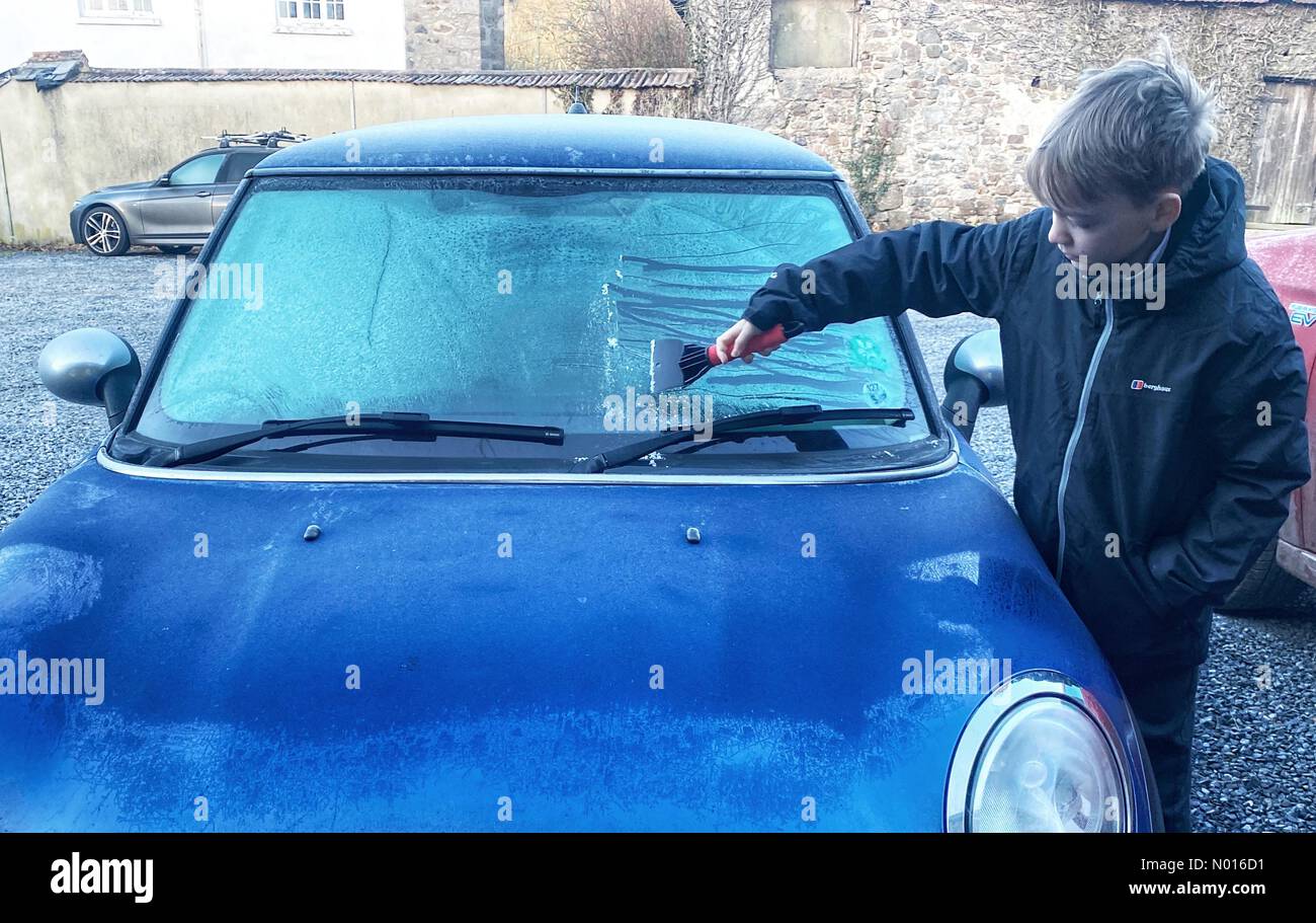 UK Wetter: Jack Porter kratzt Eis von einer Autoscheibe vor der Schule in frostigen Doddiscombsleigh, Devon, Großbritannien. 11th. Februar 2022. Credit nidpor/Alamy Live News Credit: Nidpor/StockimoNews/Alamy Live News Stockfoto