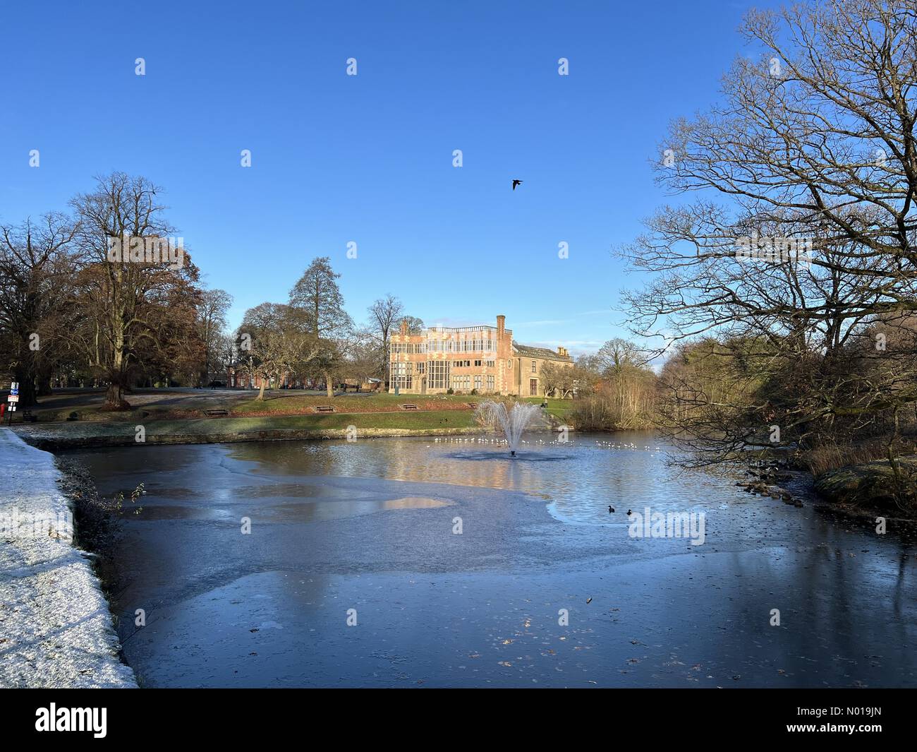 Wetter in Großbritannien: Sonnig in Chorley. Sonniger, aber kalter und eiskalter Tag im Astley Park in Chorley, Lancashire. Astley Hall und Lake Stockfoto