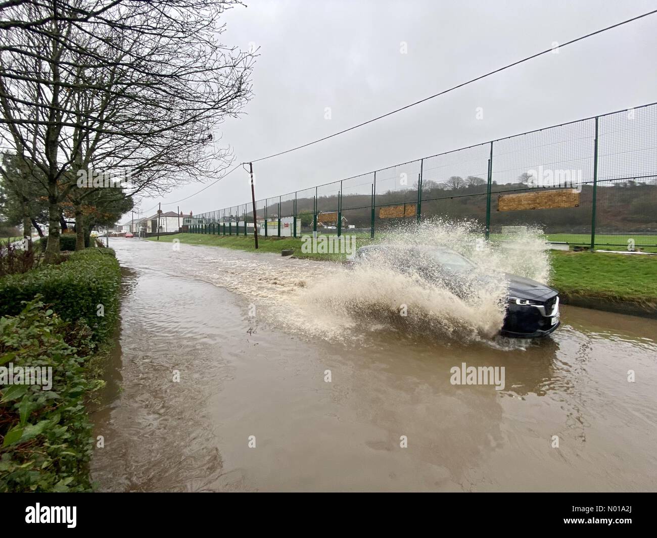 Swansea, Wales, Großbritannien. Januar 2024. Ein Auto hat heute Nachmittag Schwierigkeiten, durch die überflutete Hauptstraße in Penclawdd auf der Gower-Halbinsel bei Swansea zu kommen, als Storm Henk Großbritannien trifft. Credit: Phil Rees/StockimoNews/Alamy Live News Credit: Phil Rees/StockimoNews/Alamy Live News Stockfoto