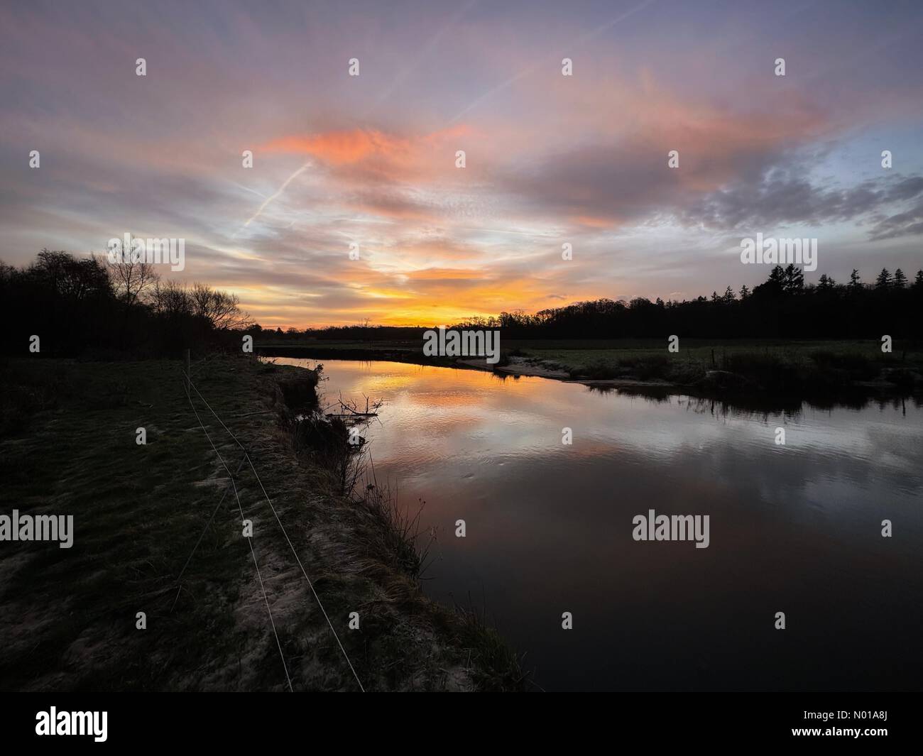 Wetter in Großbritannien: Sonnenaufgang über Godalming. Thundry Meadows, Godalming. Januar 2024. Ein wunderschöner, aber frostiger Start in das Wochenende für die Home Counties. Sonnenaufgang über dem Fluss Wey in Godalming. Quelle: Jamesjagger/StockimoNews/Alamy Live News Stockfoto