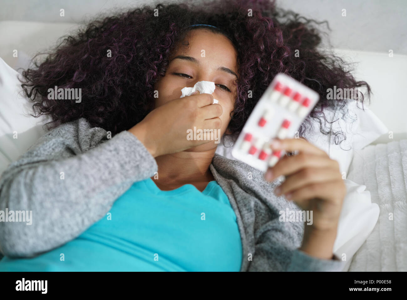 Frau im Bett zu Hause Antibiotika nehmen Für Grippe Stockfoto