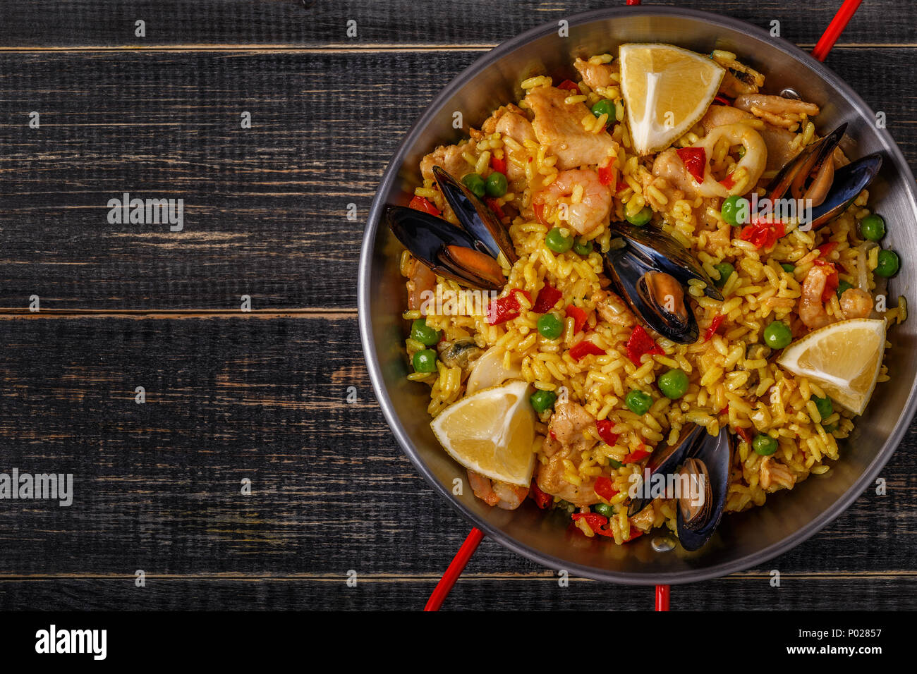 Paella mit Huhn, Meeresfrüchten, Gemüse und Safran serviert in der traditionellen Pan, Ansicht von oben. Stockfoto