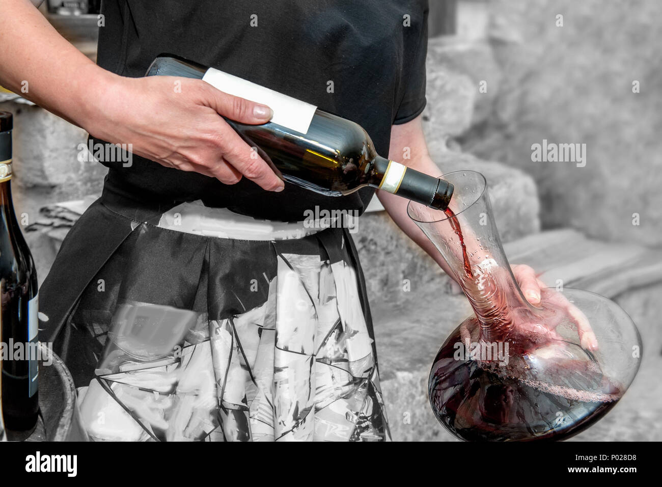 Der Sommelier gießt Wein in ein Glas aus einer Schüssel. Belüftung von Rotwein. Dekanter. Stockfoto