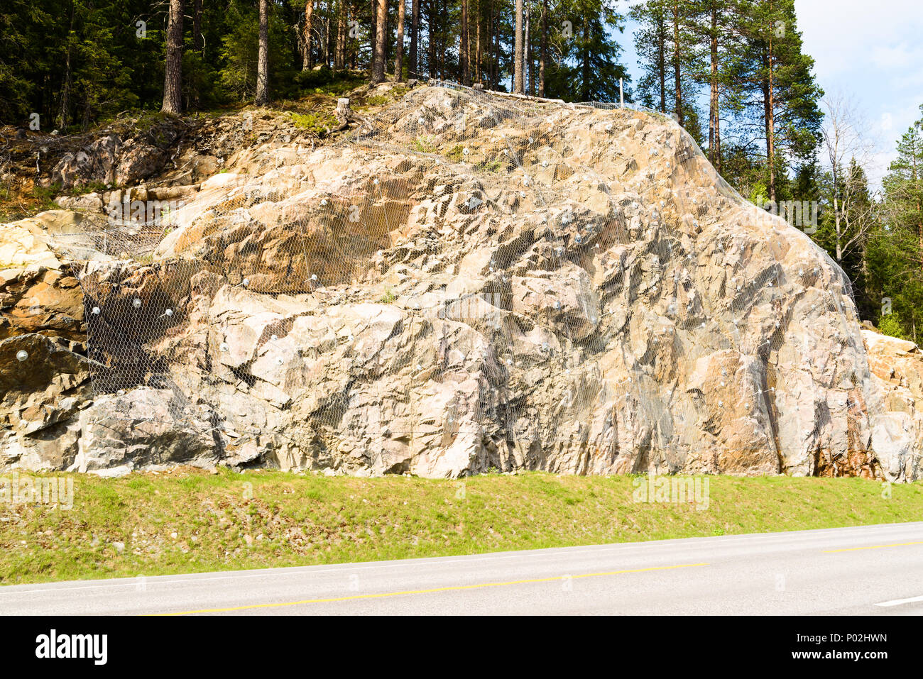 Kleine Klippe mit bergsturz Verrechnung Felsen auf der Straße unten zu verhindern. Stockfoto