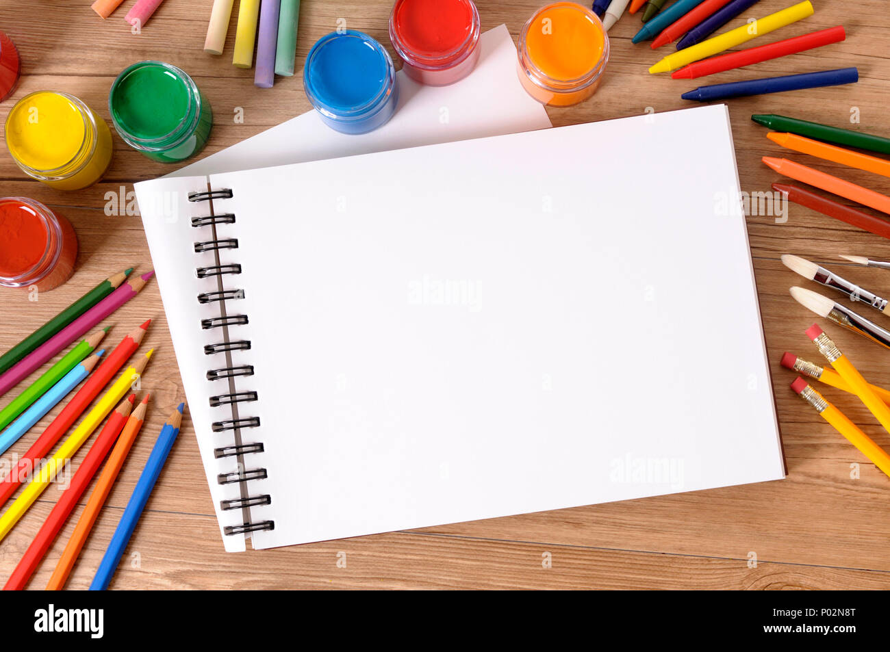 Leere weiße Kunst Buch auf der Schulbank mit verschiedenen Farben, Kreiden und Stifte. Stockfoto