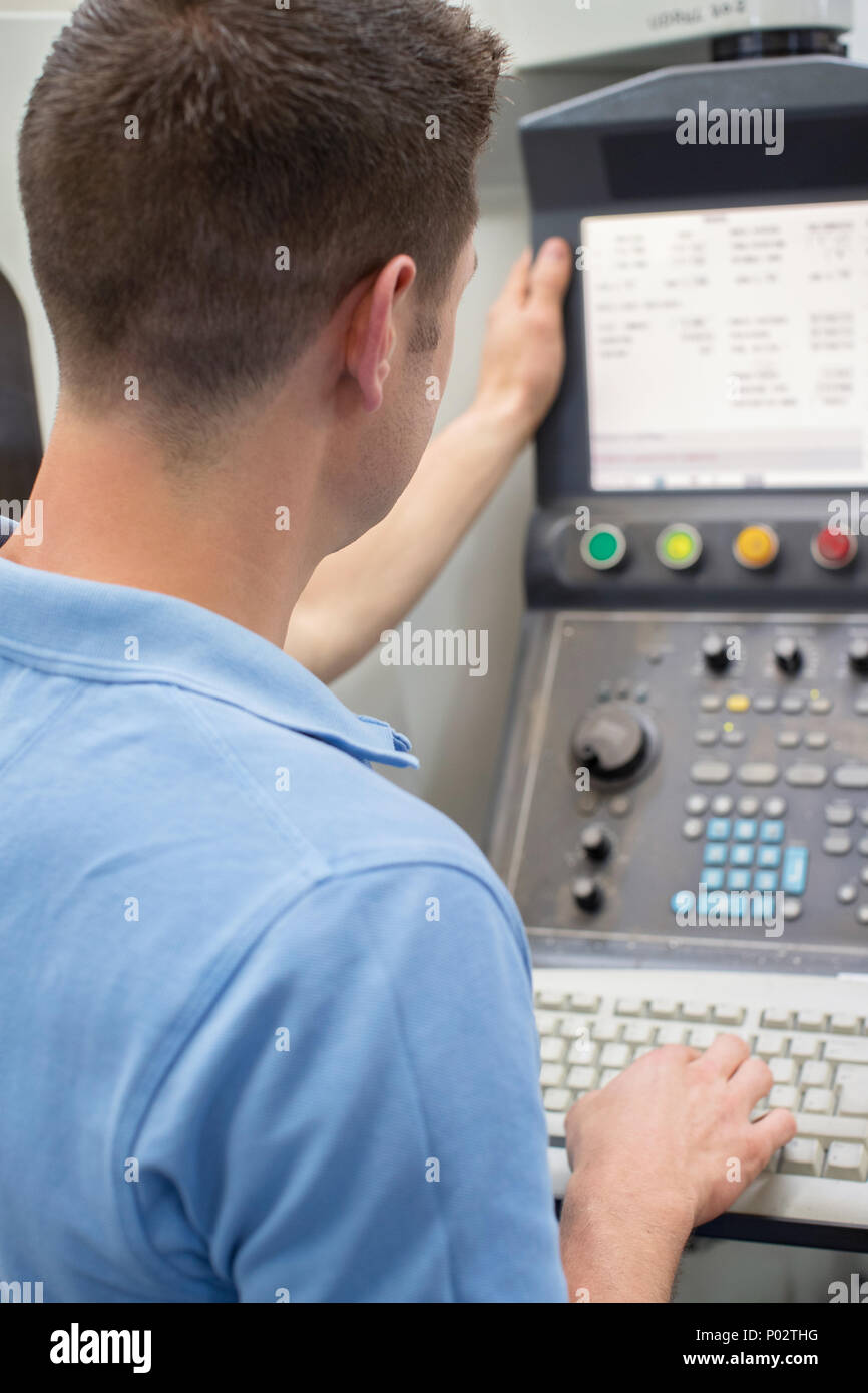 Ansicht der Rückseite des Männlichen Ingenieur der CNC-Maschine im Werk Stockfoto Ansicht der Rückseite des Männlichen Ingenieur der CNC-Maschine im Werk Stockfoto