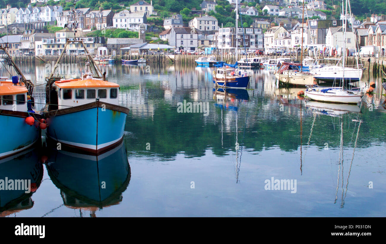 Reflexionen auf dem Wasser zu einem cornish Fischerdorf auf einer noch Sommermorgen. Stockfoto