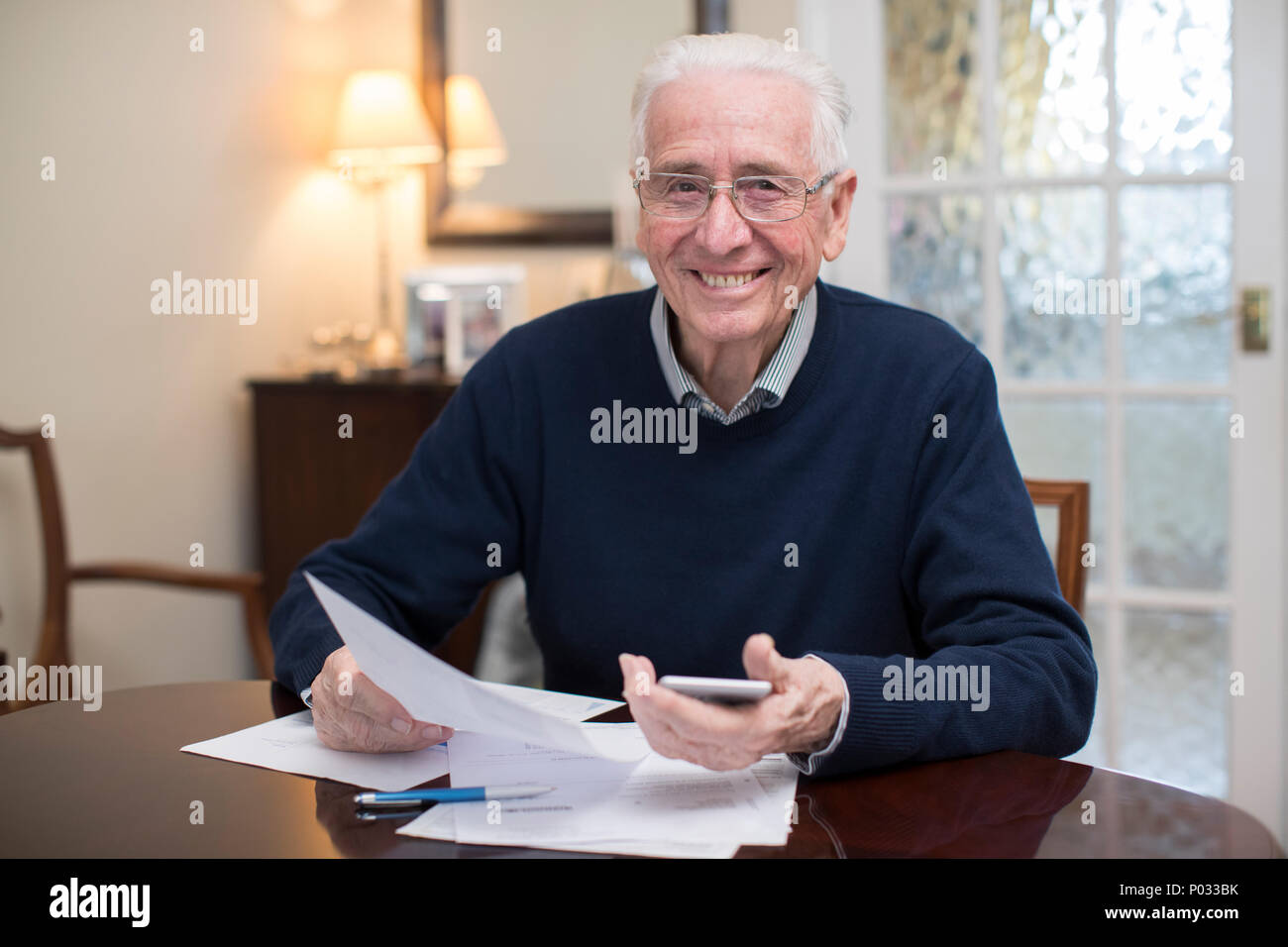 Portrait von Happy älterer Mann Überprüfung der inländischen Finanzen Stockfoto
