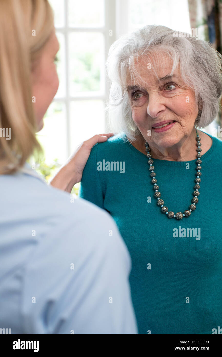Care Worker im Gespräch mit älteren Frau zu Hause Stockfoto