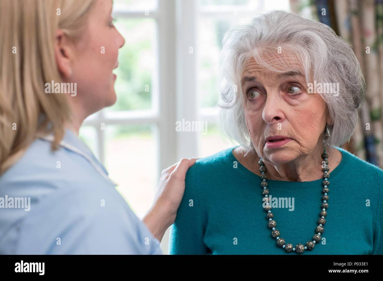 Care Worker im Gespräch mit Depressiven älteren Frau zu Hause Stockfoto