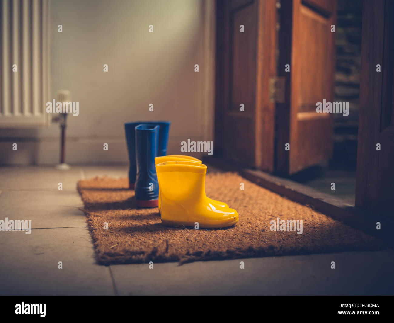 Zwei Paar Gummistiefel durch eine offene Tür Stockfoto