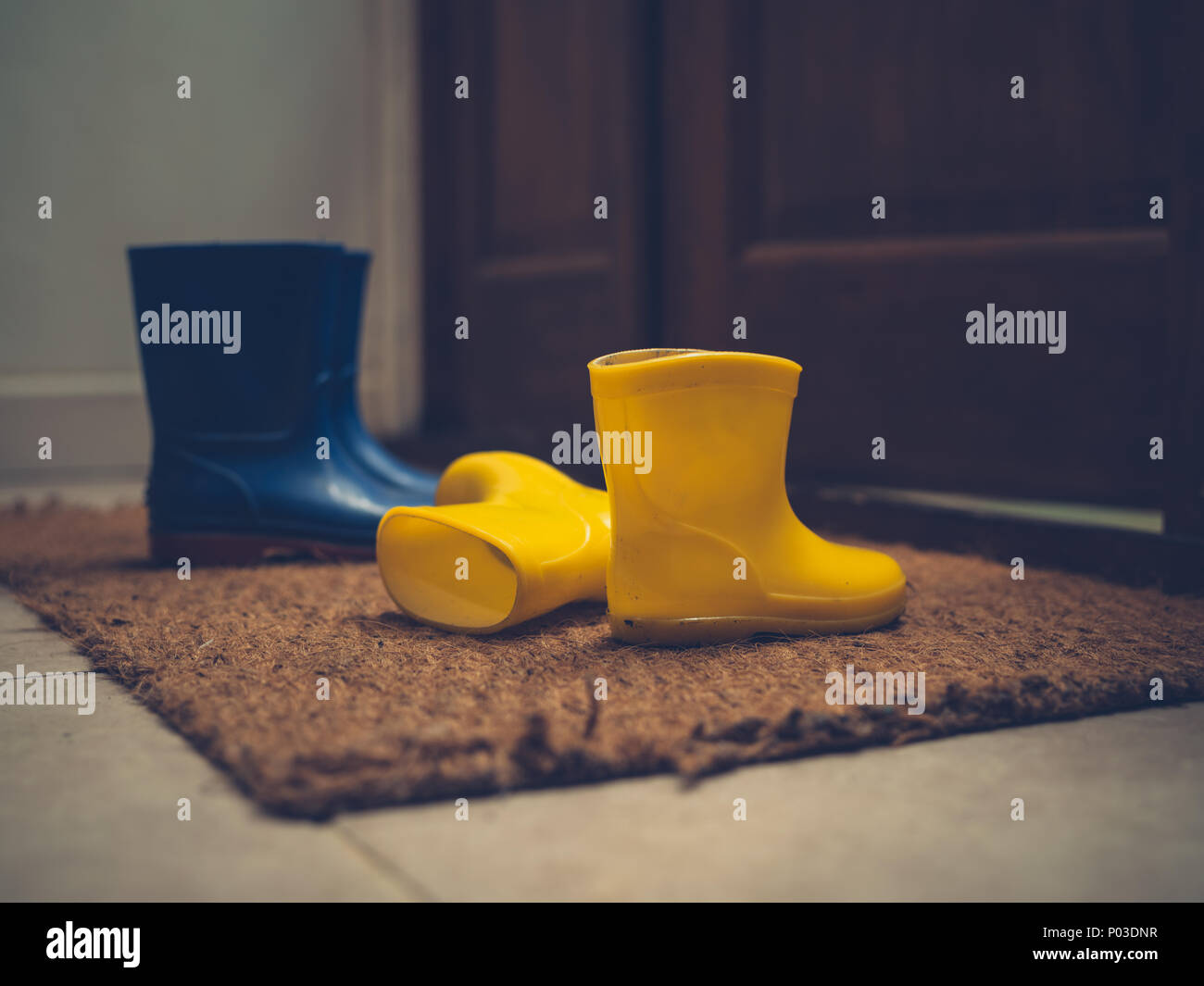 Zwei Paar Gummistiefel durch eine offene Tür Stockfoto